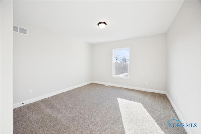 carpeted empty room featuring visible vents and baseboards