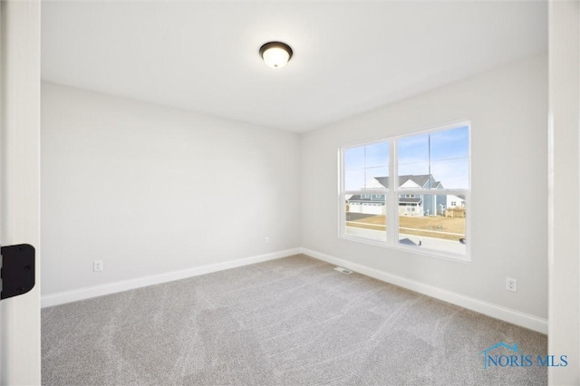 carpeted empty room with visible vents and baseboards