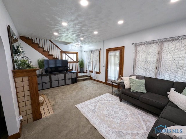 living area with baseboards, stairway, recessed lighting, and light colored carpet