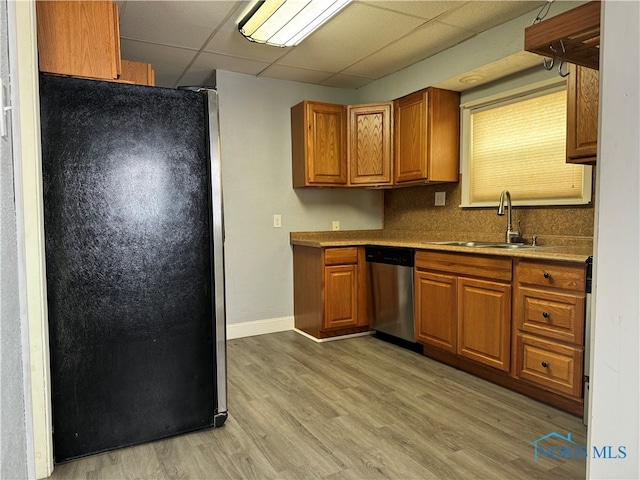 kitchen featuring light hardwood / wood-style flooring, dishwasher, sink, and black fridge