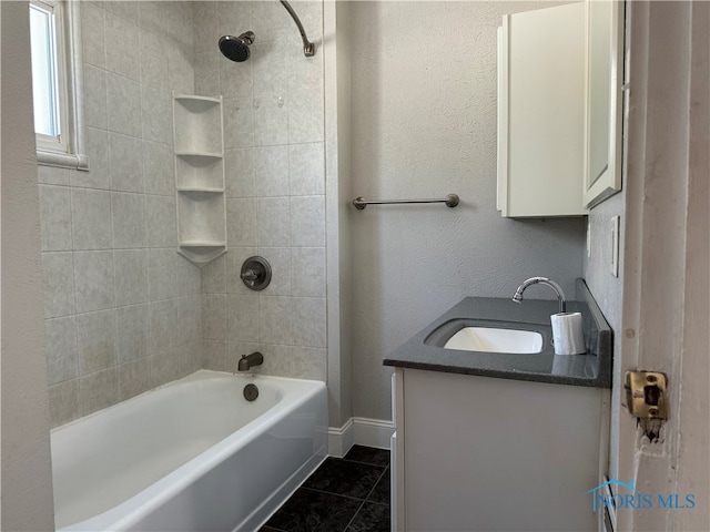 bathroom featuring vanity, tile patterned flooring, and tiled shower / bath