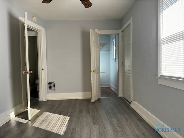 unfurnished bedroom featuring ceiling fan and dark hardwood / wood-style floors