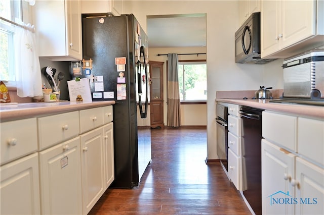 kitchen with white cabinetry, black appliances, and dark hardwood / wood-style flooring