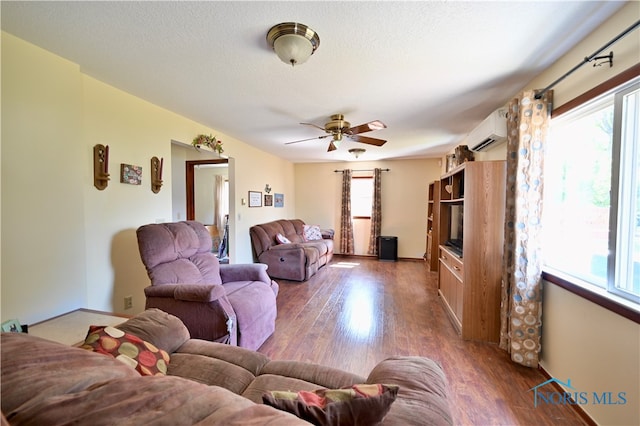 living room featuring plenty of natural light, ceiling fan, and dark hardwood / wood-style floors