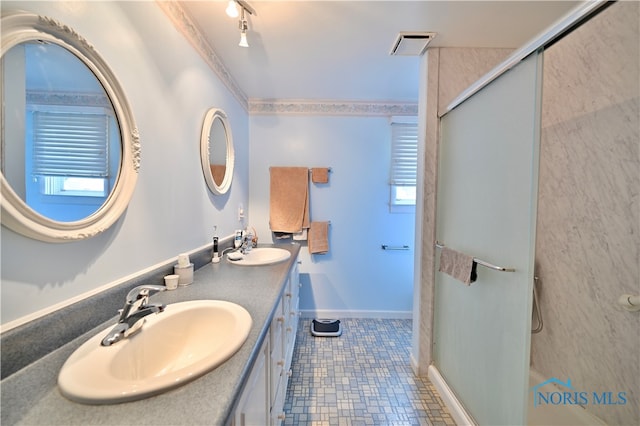 bathroom with tile patterned flooring, walk in shower, crown molding, and vanity