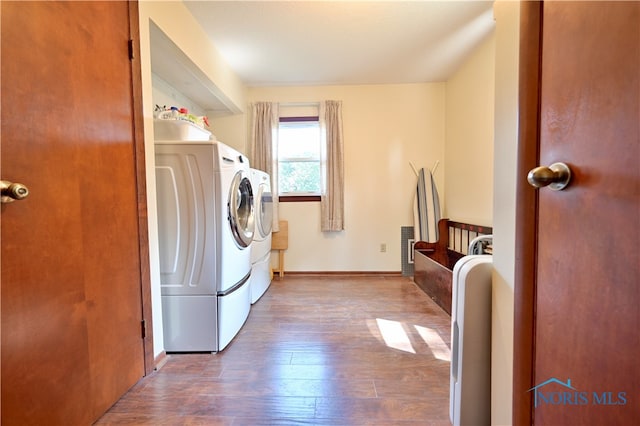 clothes washing area with wood-type flooring and separate washer and dryer