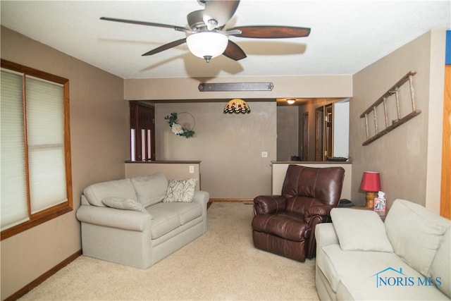 carpeted living room with ceiling fan