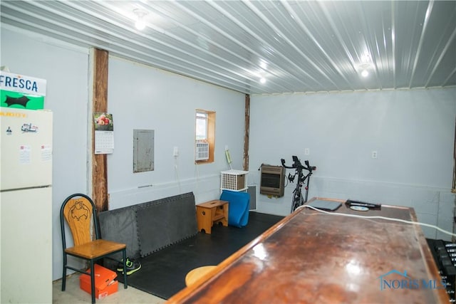 rec room featuring concrete flooring, electric panel, and heating unit