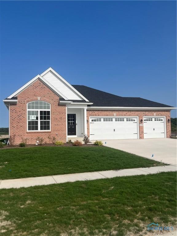 ranch-style home with brick siding, concrete driveway, a front yard, and a garage