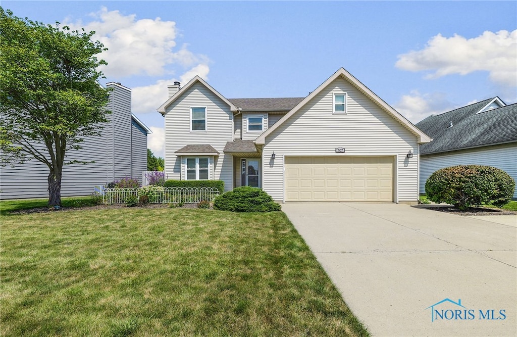 view of front of property featuring a front yard and a garage