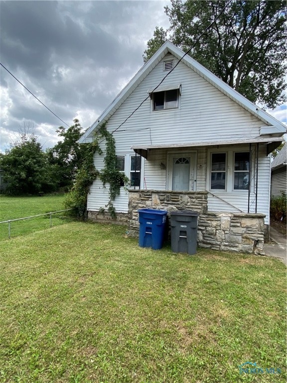 rear view of property featuring a yard