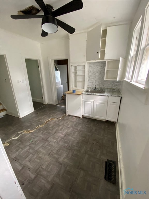 kitchen with ceiling fan, sink, backsplash, and dark parquet floors