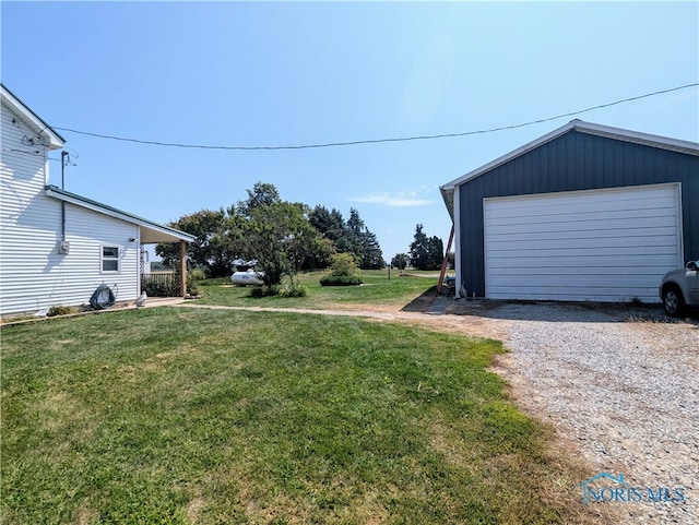 view of yard with a garage and an outbuilding