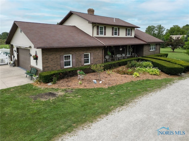 view of front facade with a front lawn, a garage, and a porch