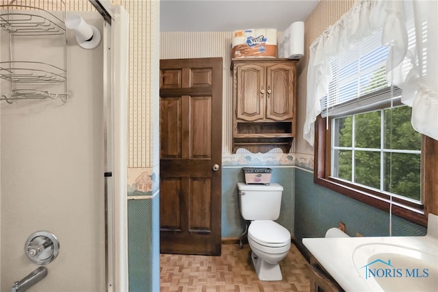 bathroom with vanity, toilet, and parquet flooring