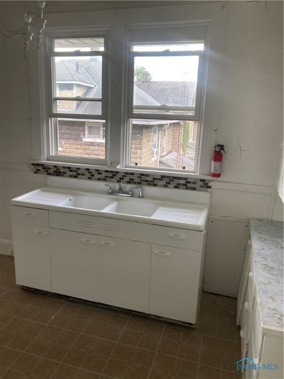 clothes washing area with sink and a healthy amount of sunlight