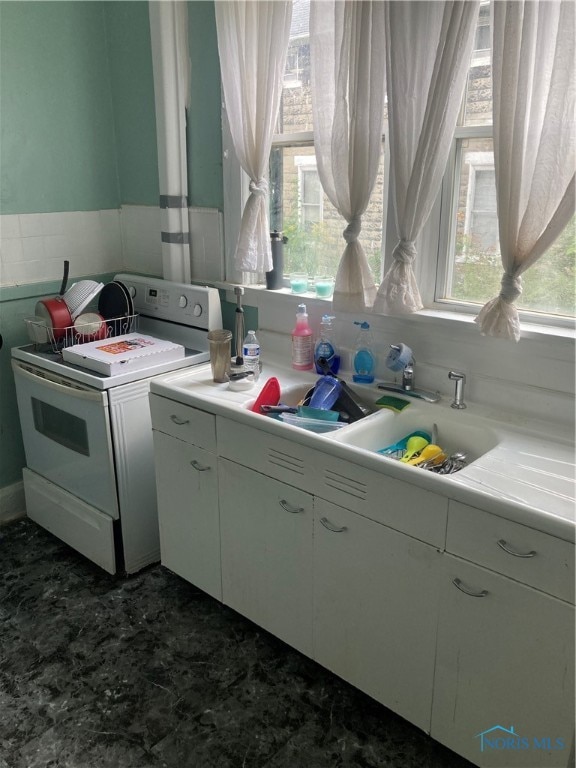 kitchen with sink, electric range, a wealth of natural light, and white cabinets