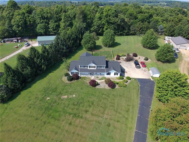 birds eye view of property featuring a forest view