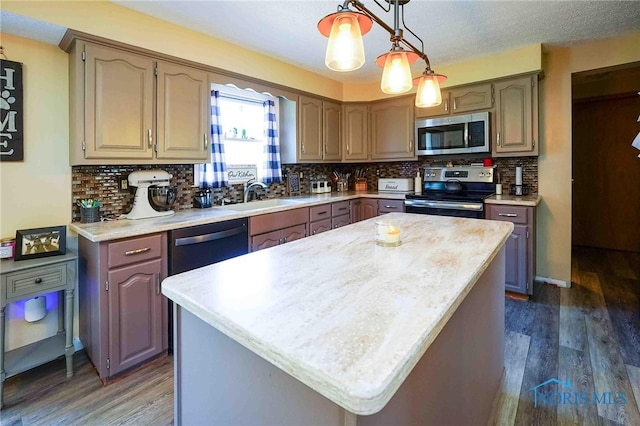 kitchen featuring dark wood-type flooring, appliances with stainless steel finishes, a center island, and sink