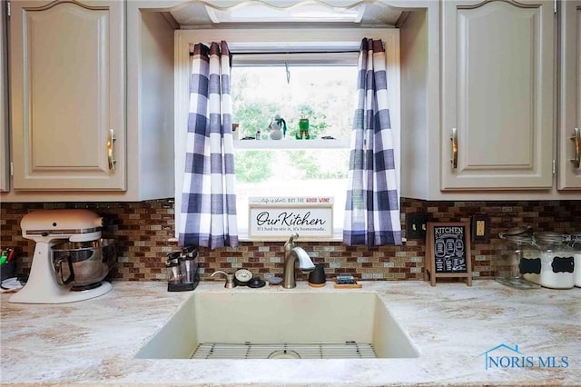kitchen featuring tasteful backsplash and a sink