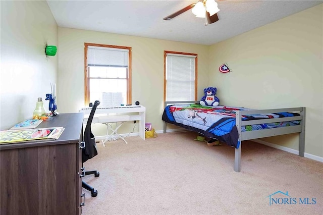 carpeted bedroom with baseboards and a ceiling fan