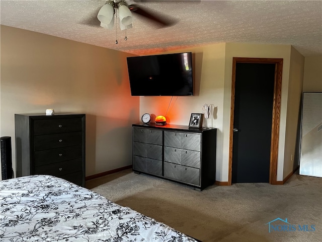 carpeted bedroom featuring a textured ceiling and ceiling fan