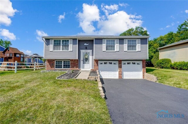 bi-level home featuring a garage and a front yard