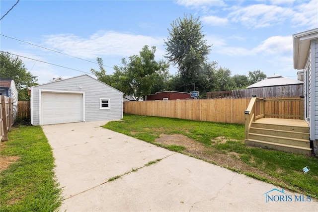 view of yard with a garage and an outbuilding