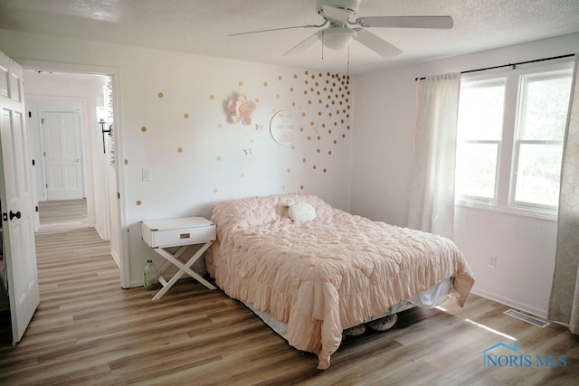 bedroom featuring a textured ceiling, hardwood / wood-style flooring, and ceiling fan