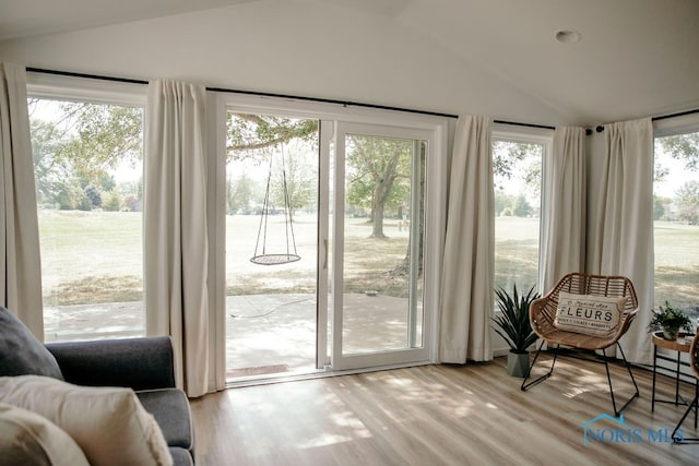 doorway with vaulted ceiling and light hardwood / wood-style floors