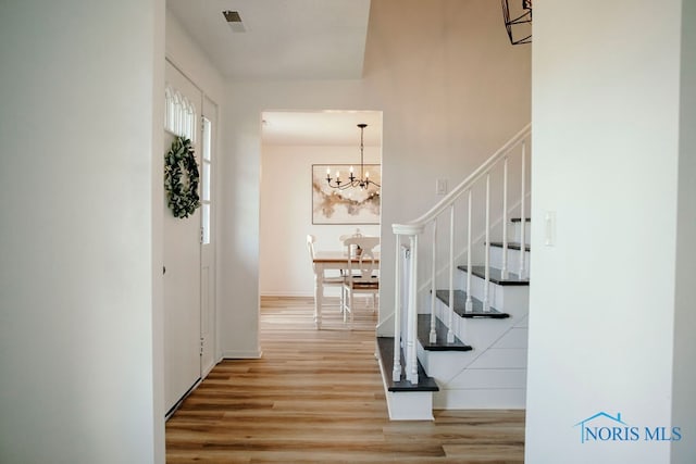 entryway featuring an inviting chandelier and light hardwood / wood-style floors