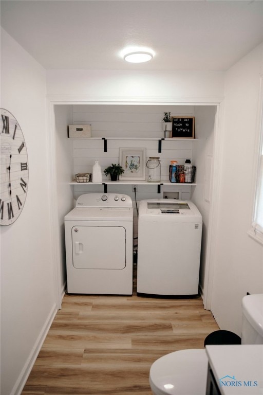 laundry area featuring washing machine and dryer and light wood-type flooring