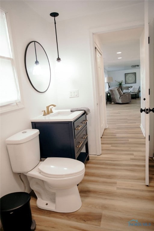 bathroom with hardwood / wood-style floors, toilet, and vanity