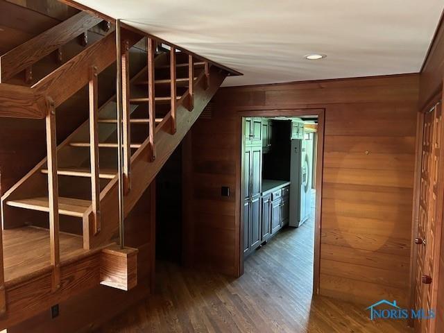 interior space featuring dark hardwood / wood-style floors and wooden walls