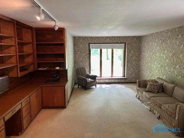 sitting room with light colored carpet and wallpapered walls