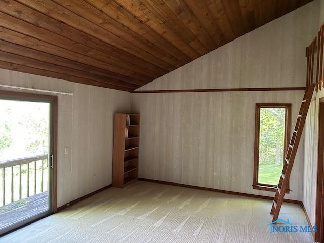 empty room featuring vaulted ceiling, wooden ceiling, and light carpet