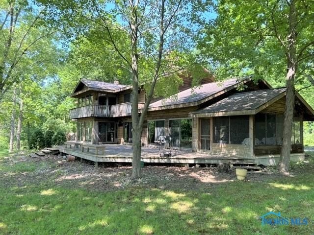 back of house featuring a lawn, a sunroom, and a deck