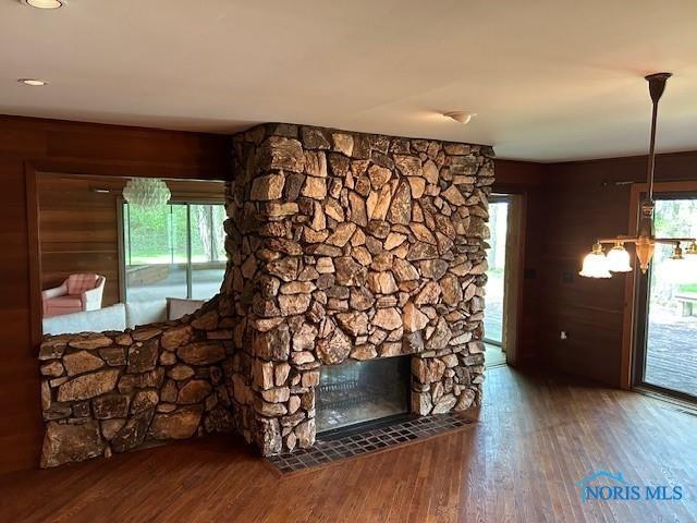 unfurnished living room with a wealth of natural light, dark wood-type flooring, and a fireplace