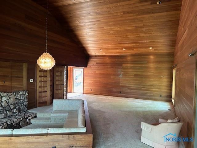 interior space with high vaulted ceiling, a notable chandelier, wood walls, carpet flooring, and wood ceiling