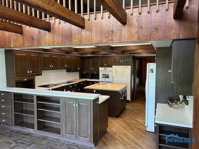 kitchen featuring a center island, open shelves, butcher block counters, dark brown cabinetry, and white appliances