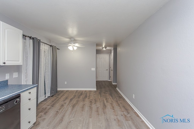 kitchen with white cabinets, dishwasher, ceiling fan, and light wood-type flooring