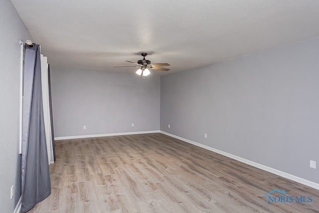 spare room with a textured ceiling, light hardwood / wood-style flooring, and ceiling fan