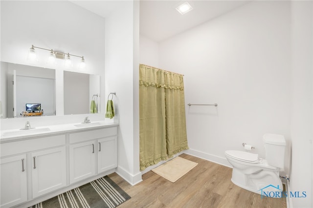 bathroom with vanity, toilet, curtained shower, and hardwood / wood-style floors