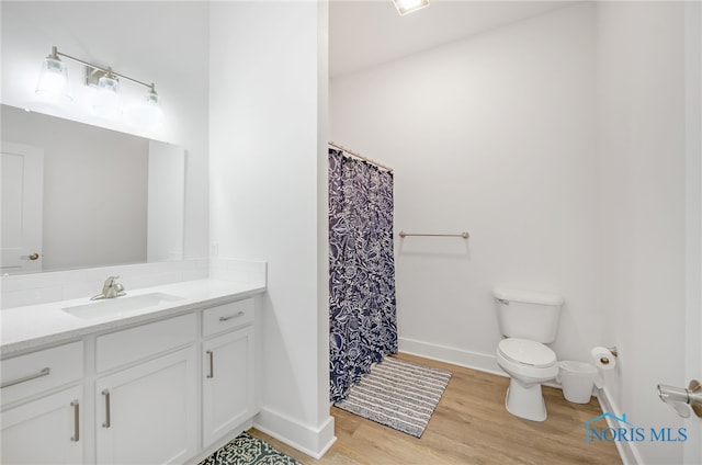 bathroom featuring vanity, toilet, and hardwood / wood-style floors