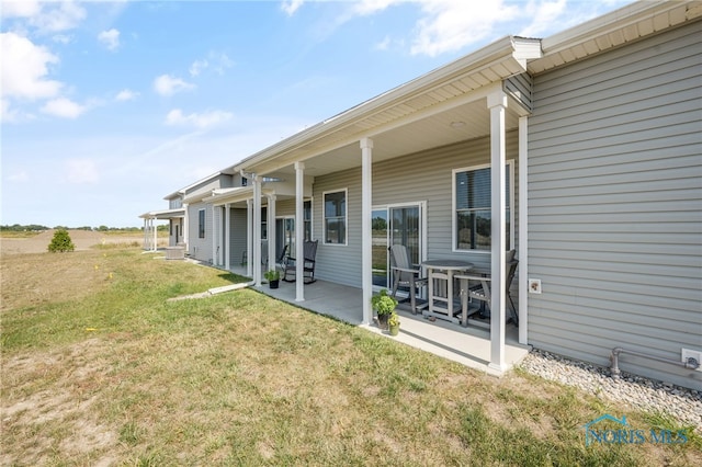 back of property featuring a yard and a patio area