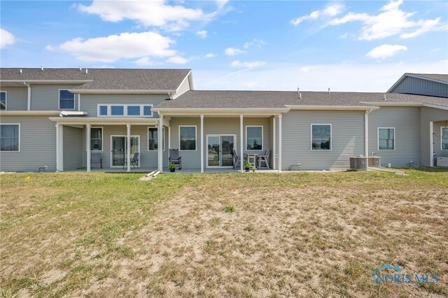 back of property with cooling unit and a lawn