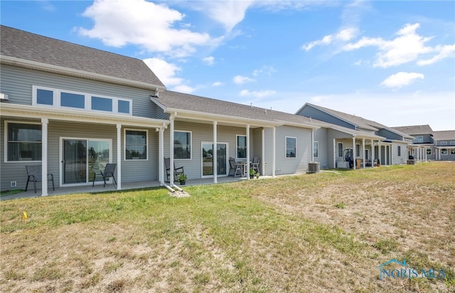 rear view of property featuring a lawn, a patio area, and central AC