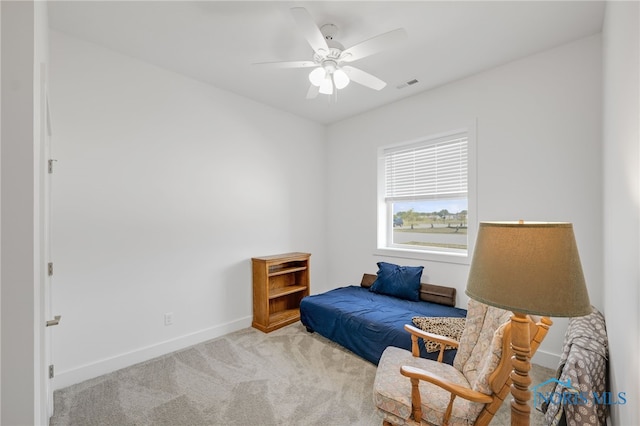 living area with light carpet and ceiling fan