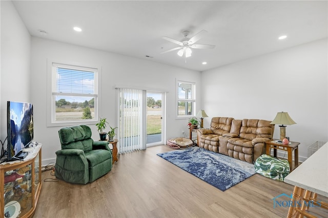 living room with light hardwood / wood-style flooring and ceiling fan