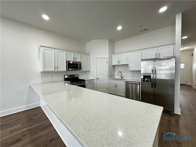 kitchen featuring sink, stainless steel appliances, kitchen peninsula, and white cabinets